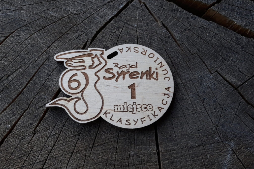 Drewniany medal z Rajdu Syrenki z grawerowaną sylwetką syrenki klasyfikacją miejsca.