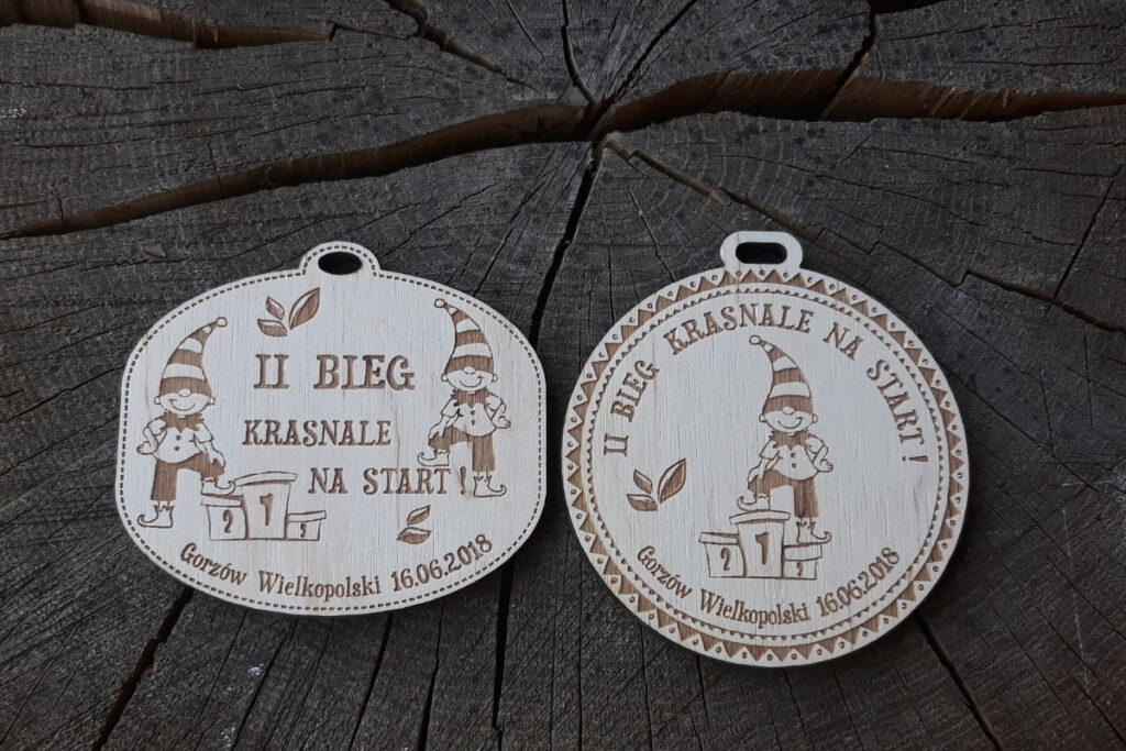 2 propozycje medalu: Drewniany medal dla dzieci na II Bieg Krasnale na start z grawerem wesołego krasnala i pamiątkowym napisem.