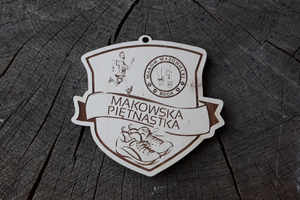 Drewniany medal biegowy na zawody Makowska Piętnastka z grawerem logotypu biegu i dystansem 15 km.