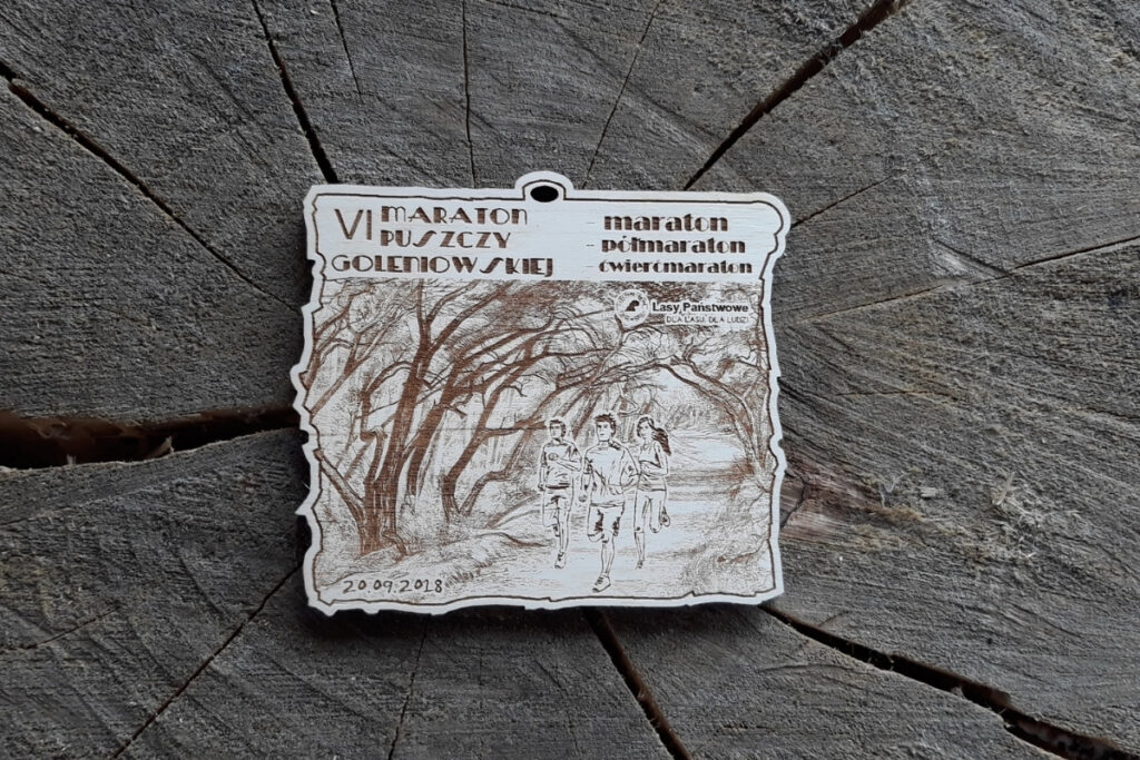 Drewniany medal biegowy na VI Maraton Puszczy Gołębiowskiej z grawerem dla dystansów maraton, półmaraton i ćwierćmaraton
