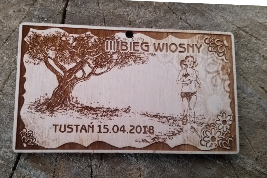 Prostokątny drewniany medal z grawerowanym napisem III Bieg Wiosny Tustań 2018.