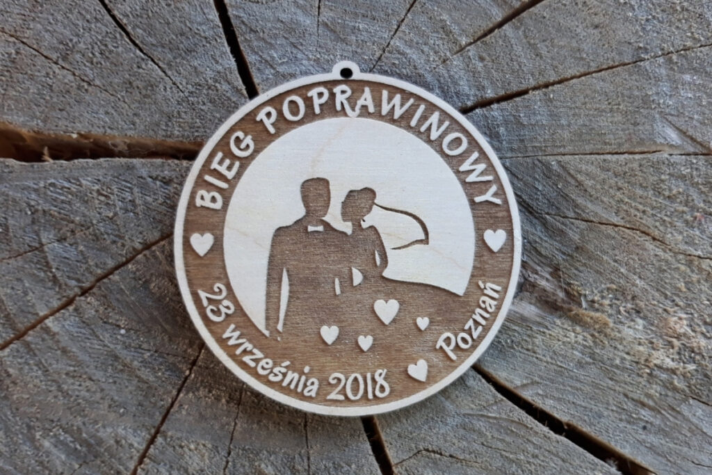 Drewniany medal na Bieg Poprawinowy z grawerem logotypu wydarzenia i datą.