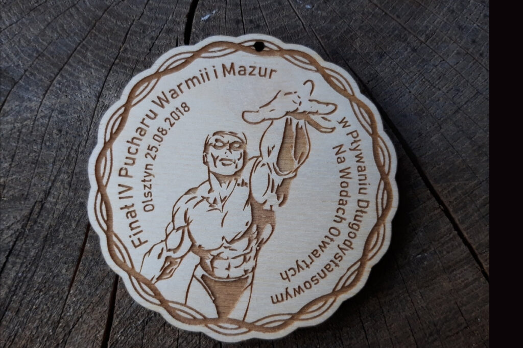 Drewniany medal na Finał IV Pucharu Warmii i Mazur z grawerem płynącego zawodnika.