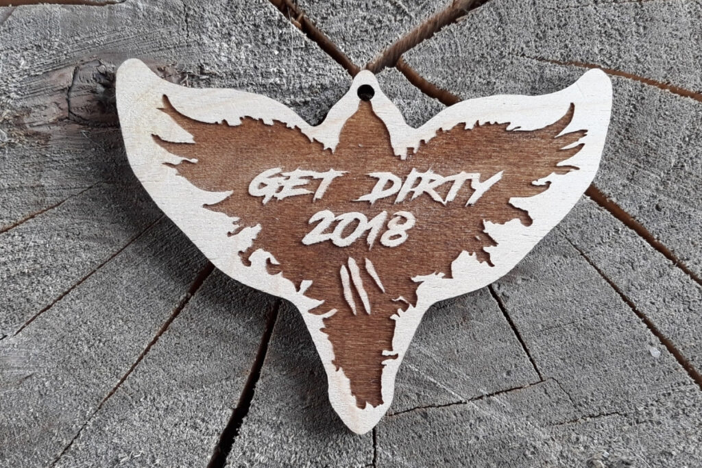 Drewniany medal na bieg przeszkodowy Get Dirty z grawerem logotypu i dynamiczną czcionką.