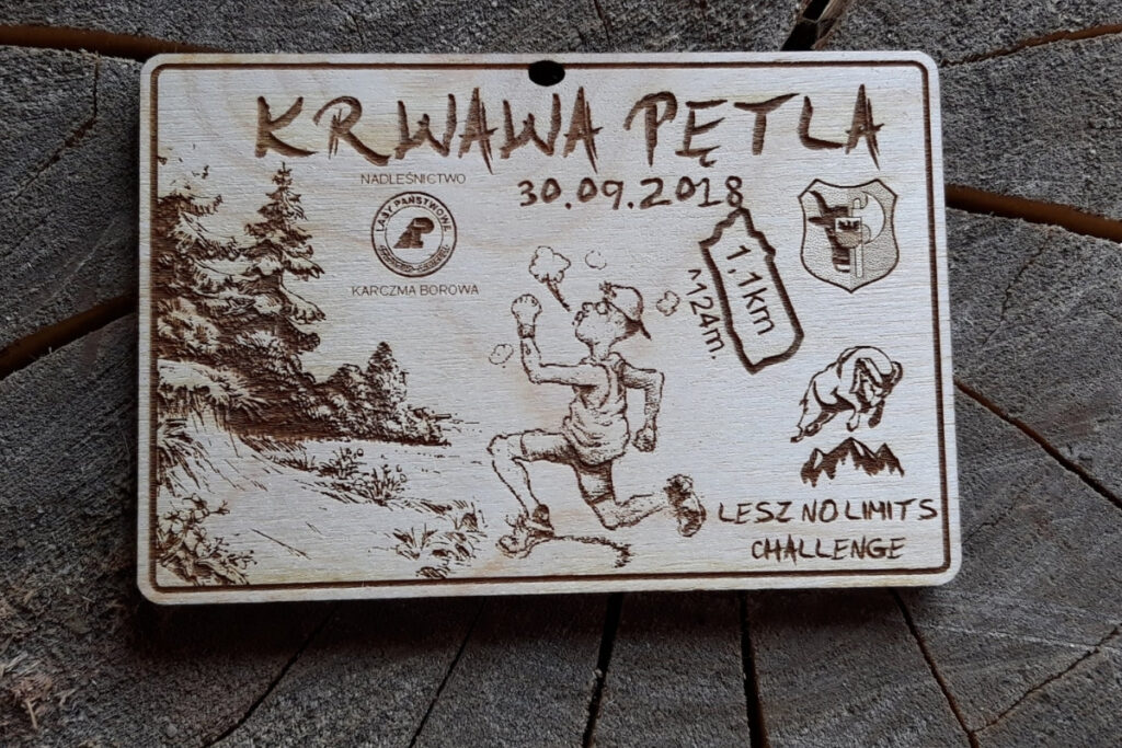 Drewniany medal Krwawa Pętla z grawerem charakterystycznego logotypu i surowym wykończeniem.