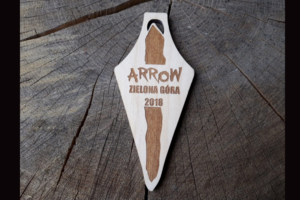 Opcja 1 (opisowa): Drewniany medal pamiątkowy Arrow Zielona Góra 2018 z grawerem logotypu i datą wydarzenia.