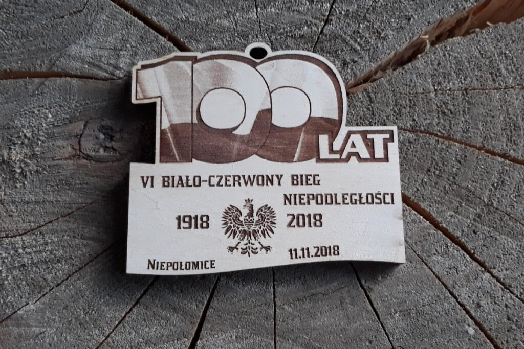 Drewniany medal na 100-lecie Niepodległości Polski z dużym napisem 100 lat i datami 1918-2018.