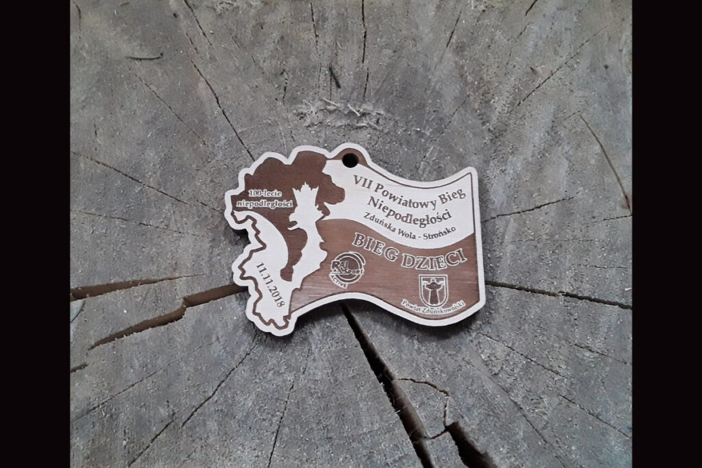 Drewniany medal dla dzieci na VII Powiatowy Bieg Niepodległości z z elementem Flagi Polski.