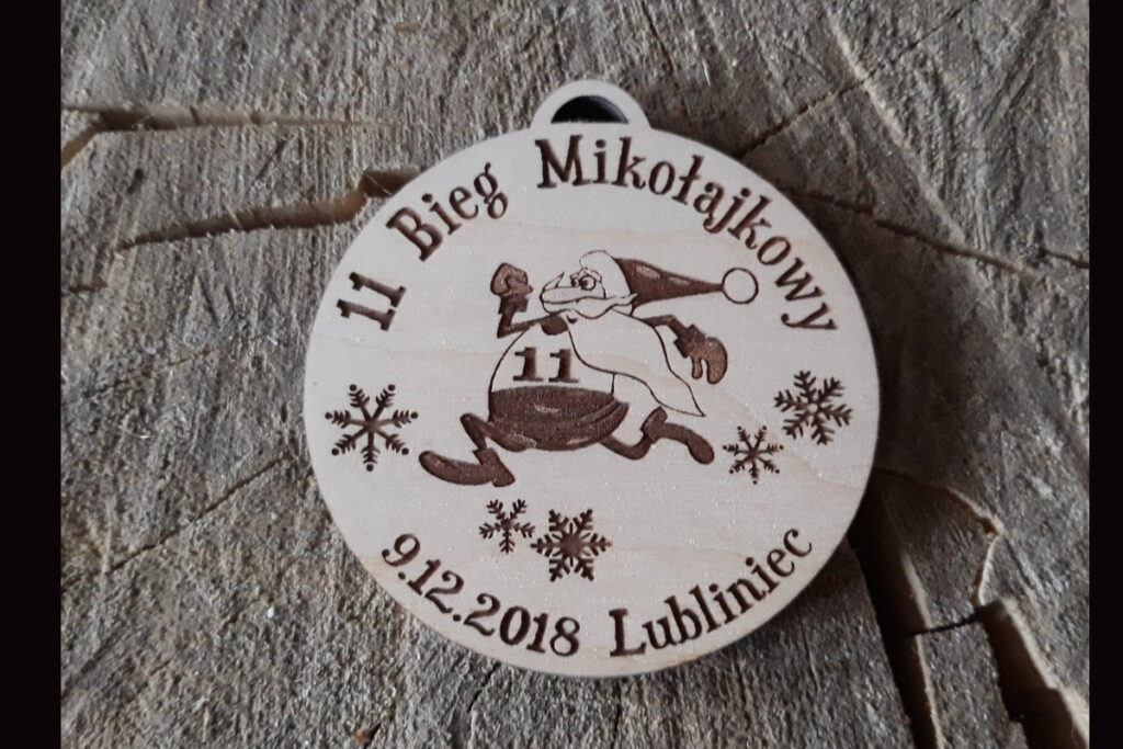Drewniany medal na 11. Bieg Mikołajkowy w Lublińcu z grawerem humorystycznego biegnącego Mikołaja.