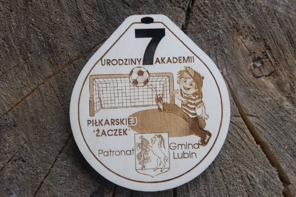 Drewniany medal na 7. urodziny Akademii Piłkarskiej Żaczek z grawerem piłki i cyfry 7.