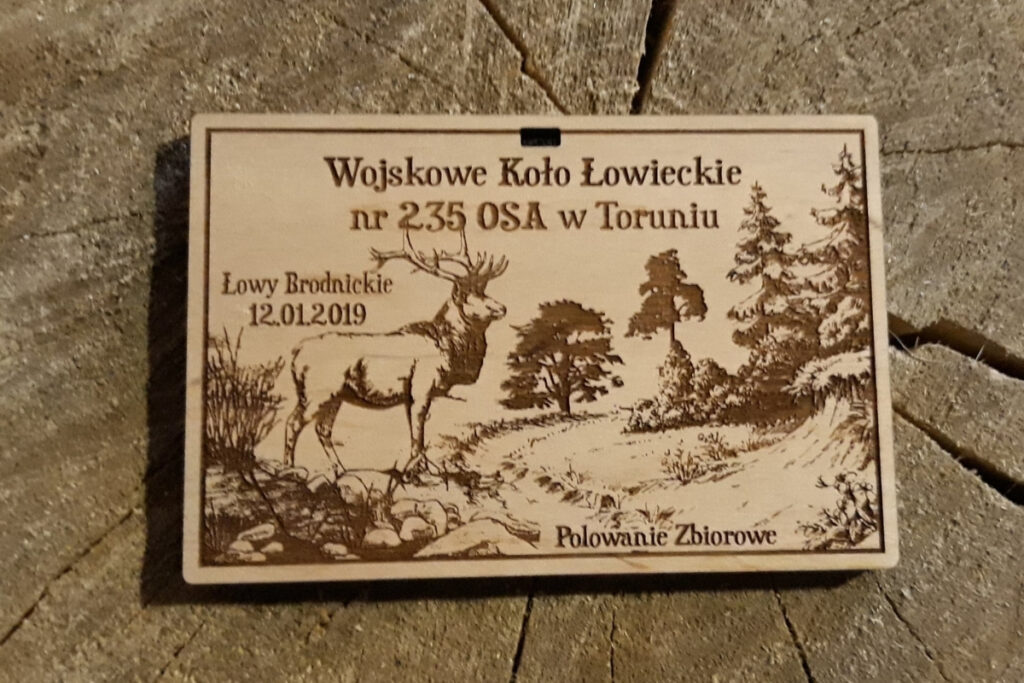 Drewniany medal z grawerem byka jelenia na łąki i drzew, wykonany z naturalnej sklejki.