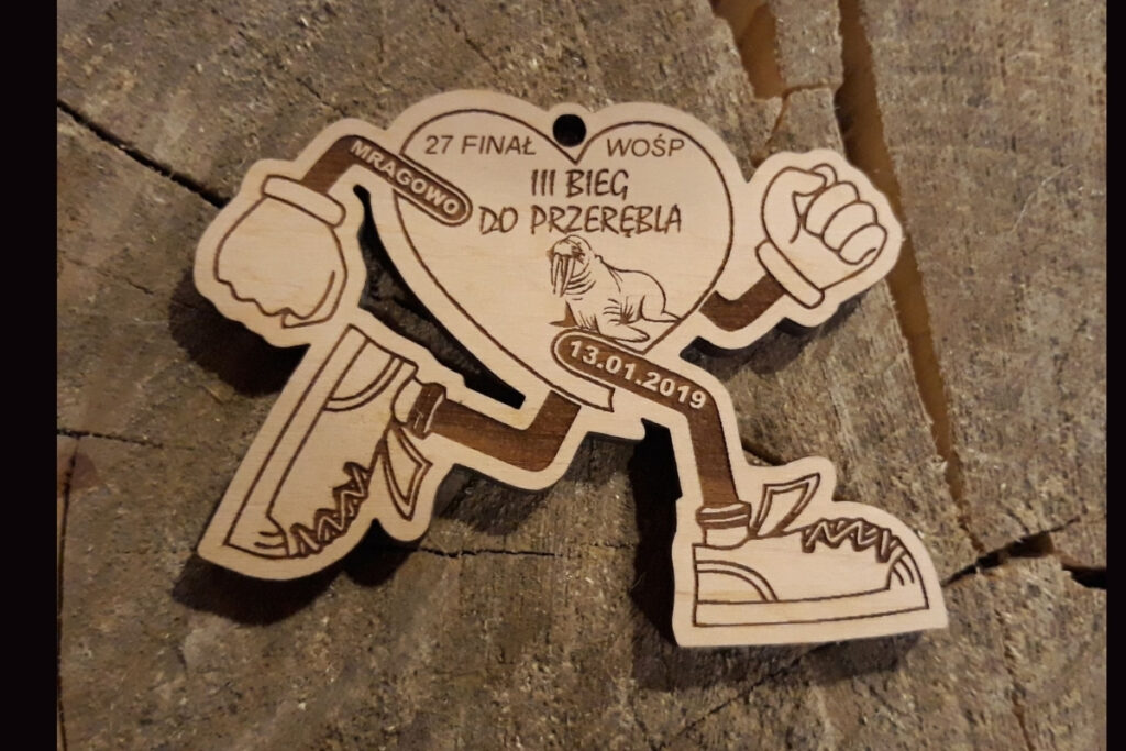 Drewniany medal w kształcie serca z nogami biegacza na III Bieg do Przerębla.
