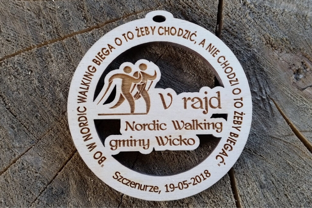 Drewniany medal ażurowy Nordic Walking Gminy Wicko z wyciętą sylwetką maszerującej osoby.