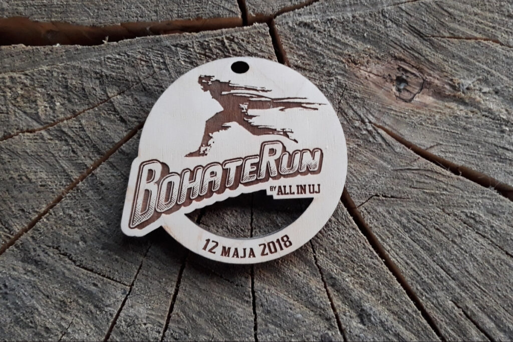 Drewniany medal pamiątkowy z biegu BohateRun z grawerowaną grafiką biegnącej postaci.