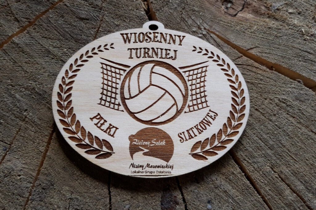 Owalny medal drewniany na Wiosenny Turniej Piłki Siatkowej z grawerowanym logotypem zawodów, grafiką piłki i siatki.