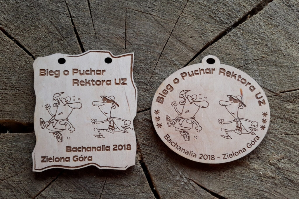 Medal wykonany z jasnego drewna z grawerowanym logo Uniwersytetu Zielonogórskiego w centrum. Obok logo widnieje napis „Bieg o Puchar Rektora UZ”. Są 2 propozycje medalu na zdjęciu.