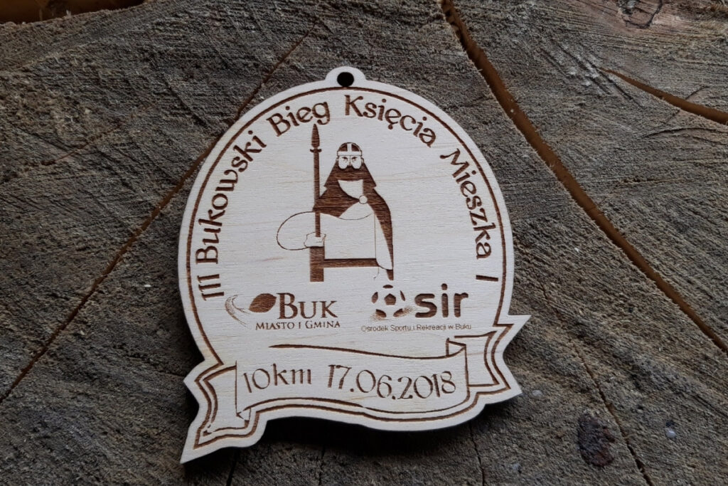 Medal wykonany z jasnego drewna z grawerem przedstawiającym popiersie Księcia Mieszka I. Wokół postaci widnieje napis „III Bukowski Bieg Księcia Mieszka I”. Medal z dziurką do zawieszenia.
