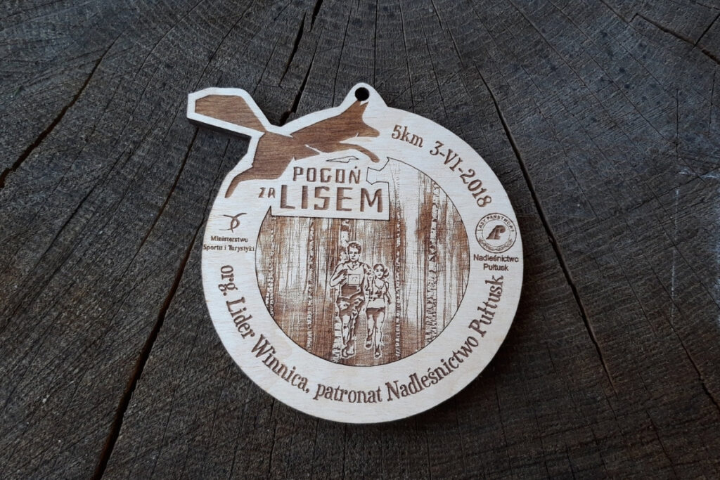 Drewniany medal z grawerem na bieg Pogoń za Lisem 2018 z sylwetką biegnącego lisa.
