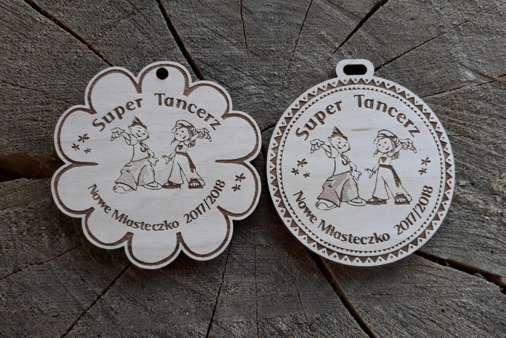 Drewniany medal pamiątkowy z grawerem „Super Tancerz” i sylwetką pary tanecznej. 2 propozycje medalu na zdjęciu.