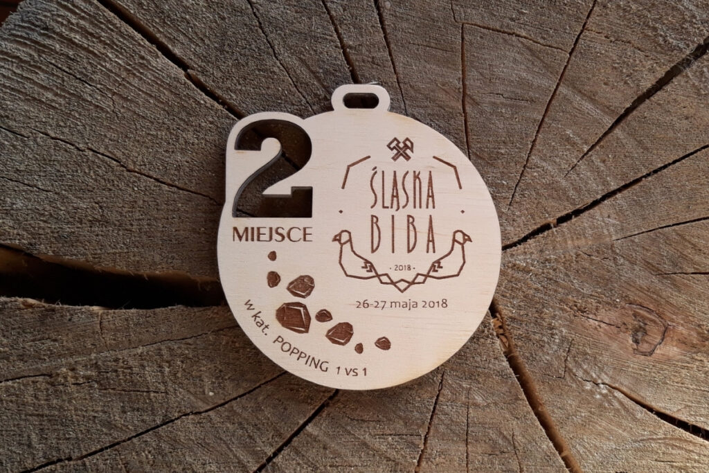 Drewniany medal Śląska Biba z ażurowo wyciętą cyfrą oznaczającą zajęte miejsce.