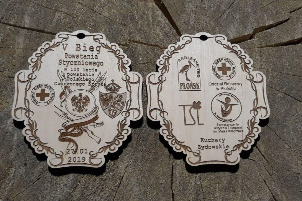 Pamiątkowy drewniany medal na V Bieg Powstania Styczniowego z grawerowanym symbolem powstańczym.
