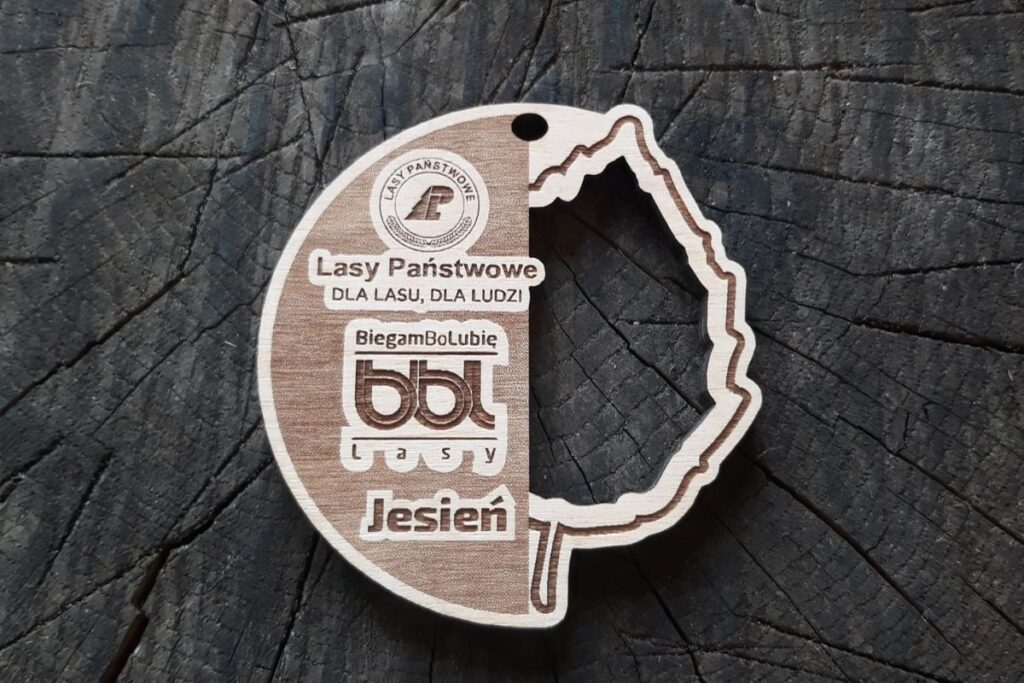 Drewniany medal BiegamBoLubię Lasy z ażurowo wyciętym liściem.