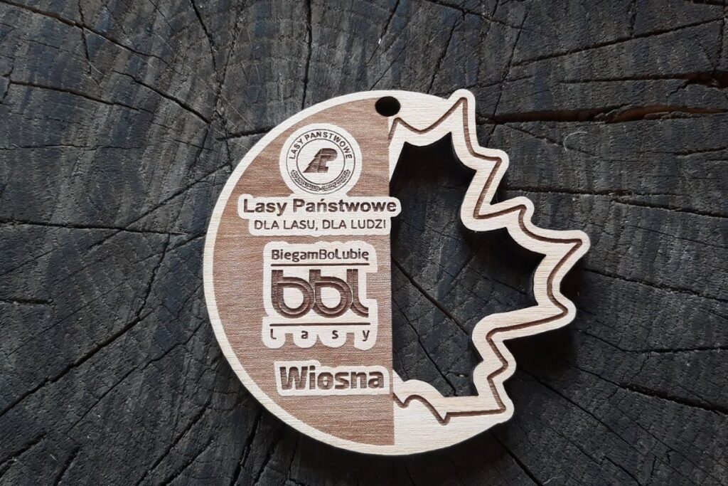 Drewniany medal BiegamBoLubię Lasy z ażurowo wyciętym liściem.