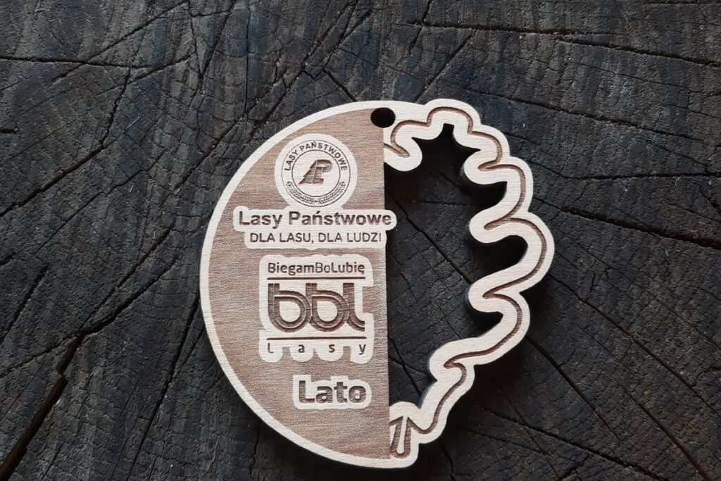 Drewniany medal BiegamBoLubię Lasy z ażurowo wyciętym liściem.