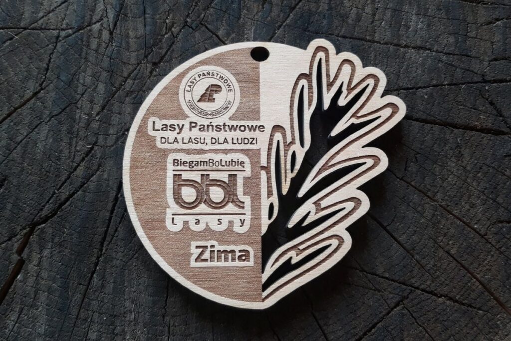 Drewniany medal BiegamBoLubię Lasy z ażurowo wyciętym liściem.