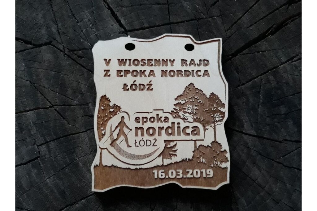 Ekologiczne trofeum na rajd pieszy – personalizowany medal z drewna z motywem drzew i logotypem z sylwetką maszerującego mężczyzny.