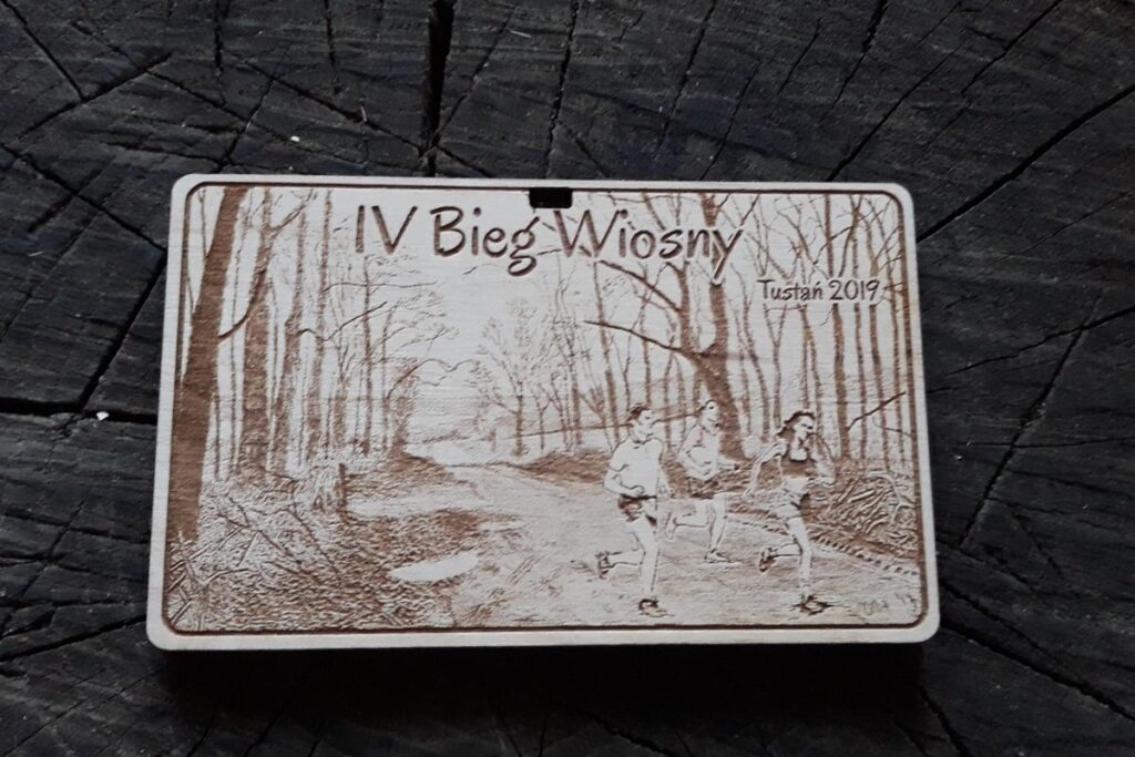 Ekologiczne trofeum sportowe z drewna – medal pamiątkowy z motywem wiosennym, lasem i biegaczami na wiosenny bieg.