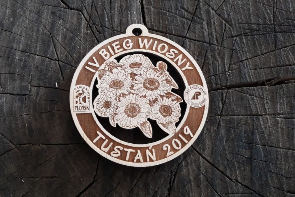 Pamiątkowy medal drewniany z motywem wiosennym i precyzyjnym grawerem daty oraz miejsca wydarzenia.