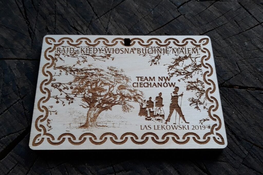 Drewniany medal pamiątkowy na rajd pieszy z grawerowanymi detalami, zawieszony na ekologicznym sznurku.