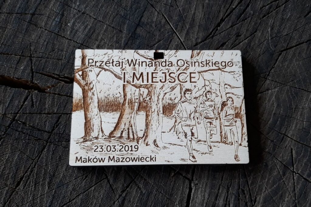 Drewniany medal na Przełaje Winanda Osińskiego, styl crossowy, grawerowany laserowo motyw lasu i biegaczy.