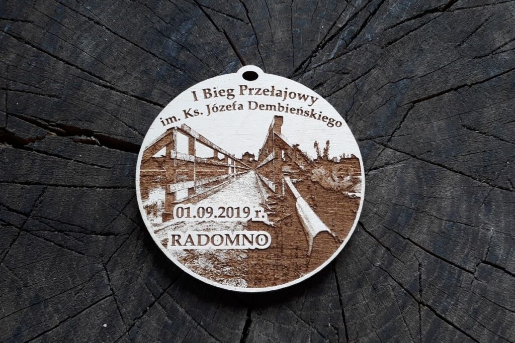 Drewniany medal pamiątkowy na Bieg Przełajowy im. ks. Józefa Dembińskiego, grawerowany laserowo, styl ekologiczny.