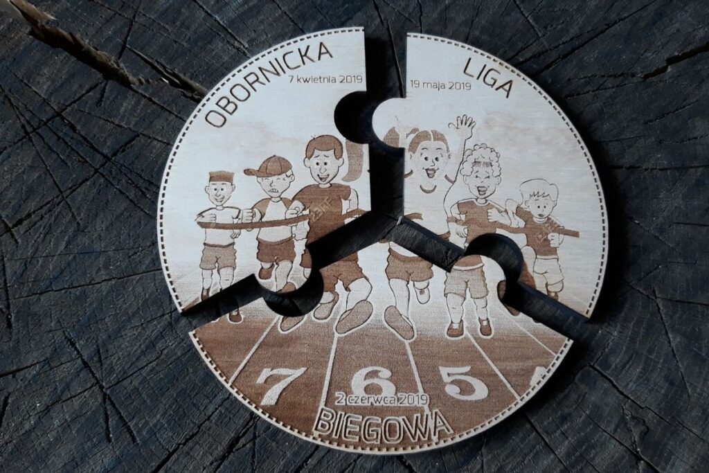 3 drewniane medale które są ze sobą dopasowane w formie puzzli i tworzą grafikę biegnących dzieci.