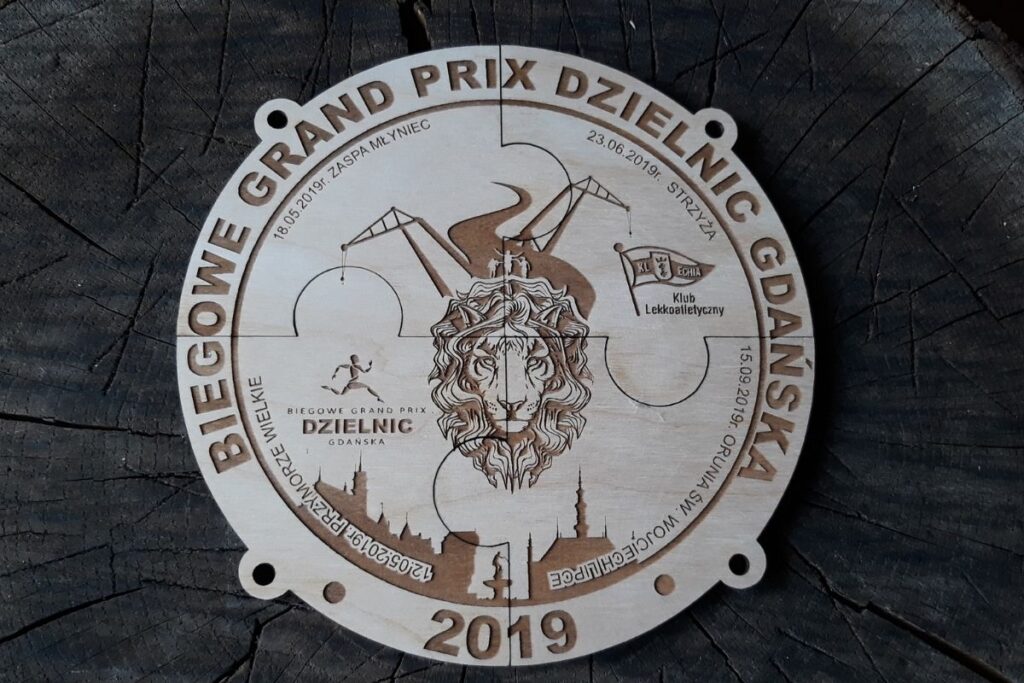 Zestaw drewnianych medali w kształcie puzzli, które po złożeniu tworzą okrągłą tablicę z charakterystyczną grafiką dzielnic Gdańska i logo biegów.