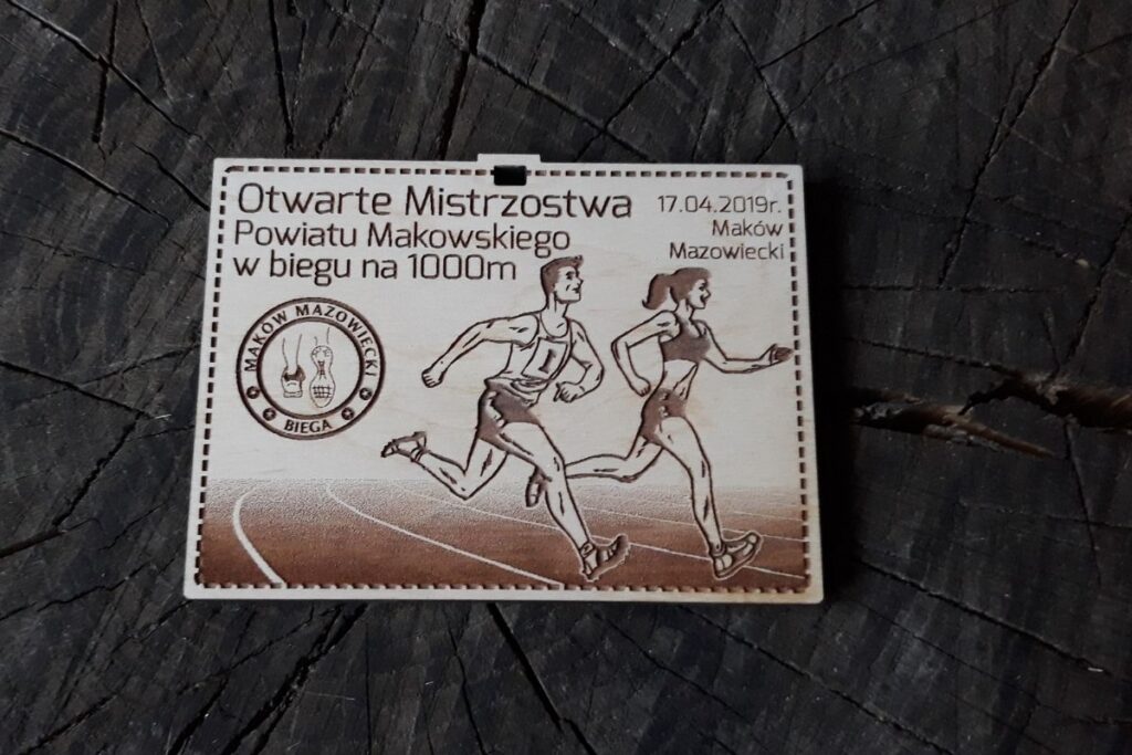 Drewniany medal prostokątny, ekologiczne trofeum na mistrzostwa powiatu makowskiego, grawerowana pamiątka z drewna w formie prostokątu.