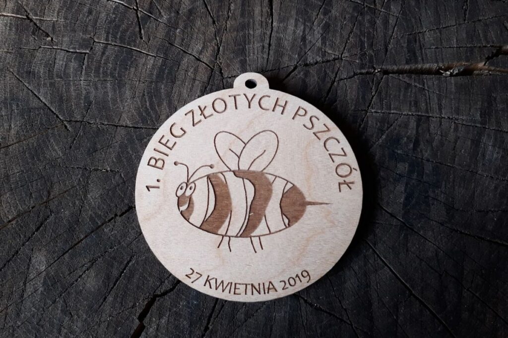 Ekologiczny medal z drewna z motywem pszczoły, pamiątka na pierwszy bieg charytatywny lub sportowy, grawer laserowy w drewnie.
