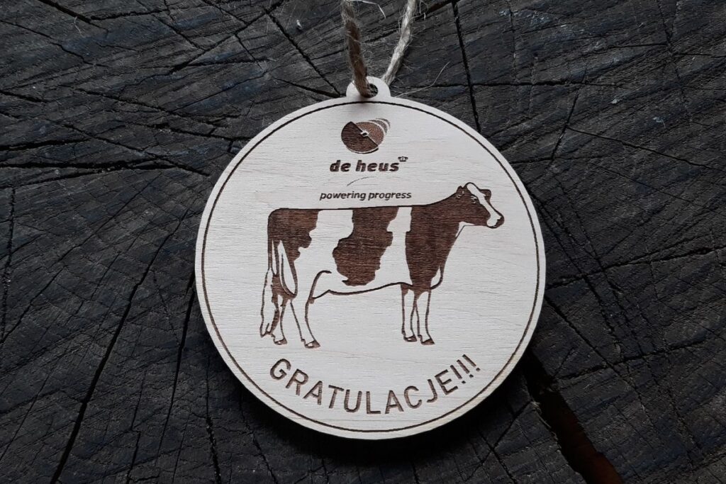 Zabawny medal z drewna z motywem krowy.