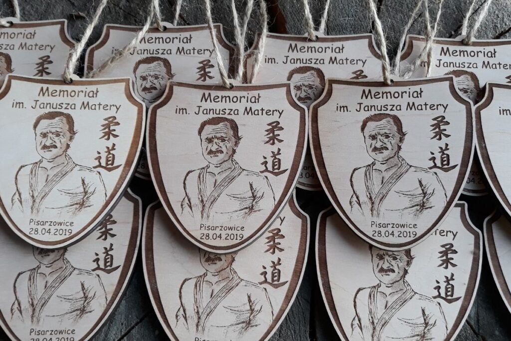 Ekologiczne trofeum drewniane tarcza, medal na memoriał sportowy, grawerowana pamiątka z drewna z motywem wizerunku patrona Memoriału Janusza Matery.