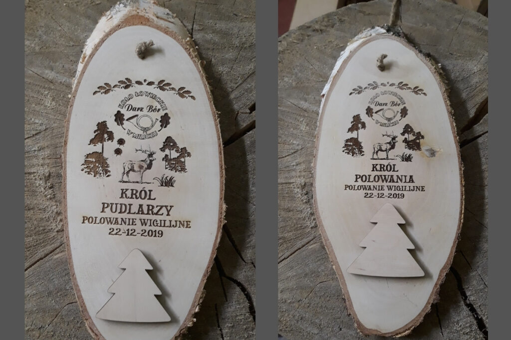 Dwa medale z naturalnych, skośnie ciętych plastrów drewna z korą; jeden dla Króla Polowania, drugi dla Króla Pudlarzy.