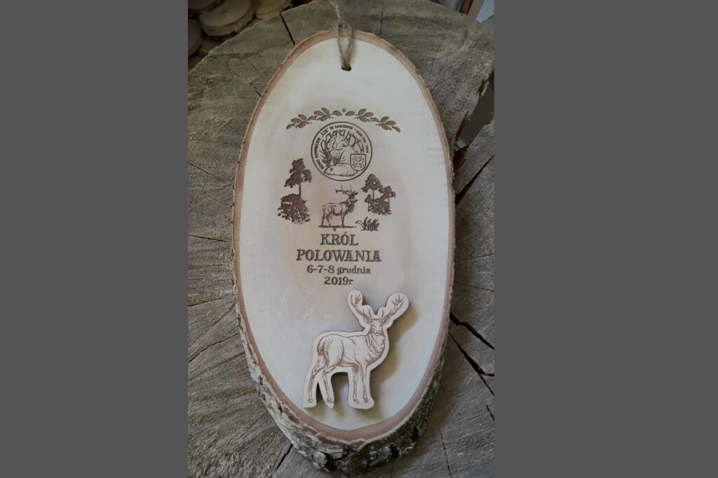 Duży medal myśliwski wykonany ze skośnego plastra brzozy z naturalną korą, grawerem wieńca jelenia i napisem Król Polowania.