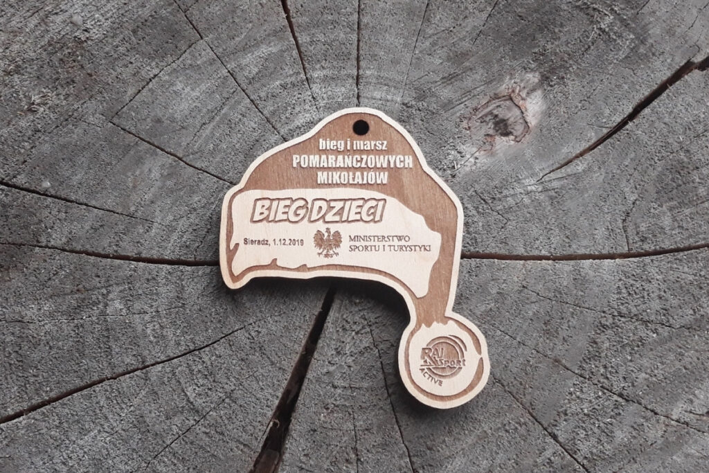 Drewniany medal w kształcie czapki mikołaja z napisem Bieg i Marsz Pomarańczowych Mikołajów