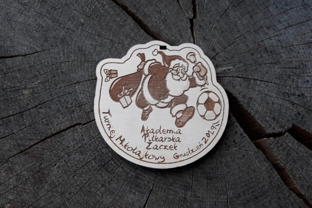 Medal na mikołajkowy turniej piłki nożnej, drewniane trofeum piłkarskie dla dzieci, eko medal z Mikołajem piłkarzem, pamiątka sportowa z grawerem.