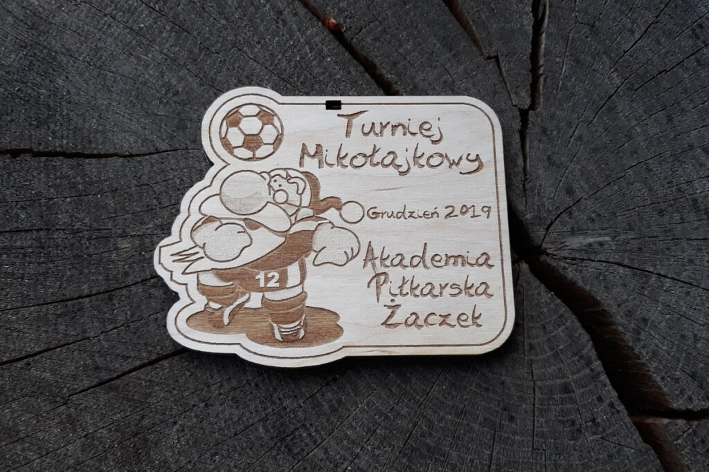 Medal na mikołajkowy turniej piłki nożnej, drewniane trofeum piłkarskie dla dzieci, eko medal z Mikołajem piłkarzem, pamiątka sportowa z grawerem.