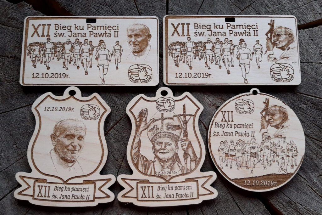 Projekty medali papieskich z drewna, medale na bieg Jana Pawła II, eko trofea religijne, pamiątka biegu papieskiego grawerowana, drewniane medale z wizerunkiem papieża.