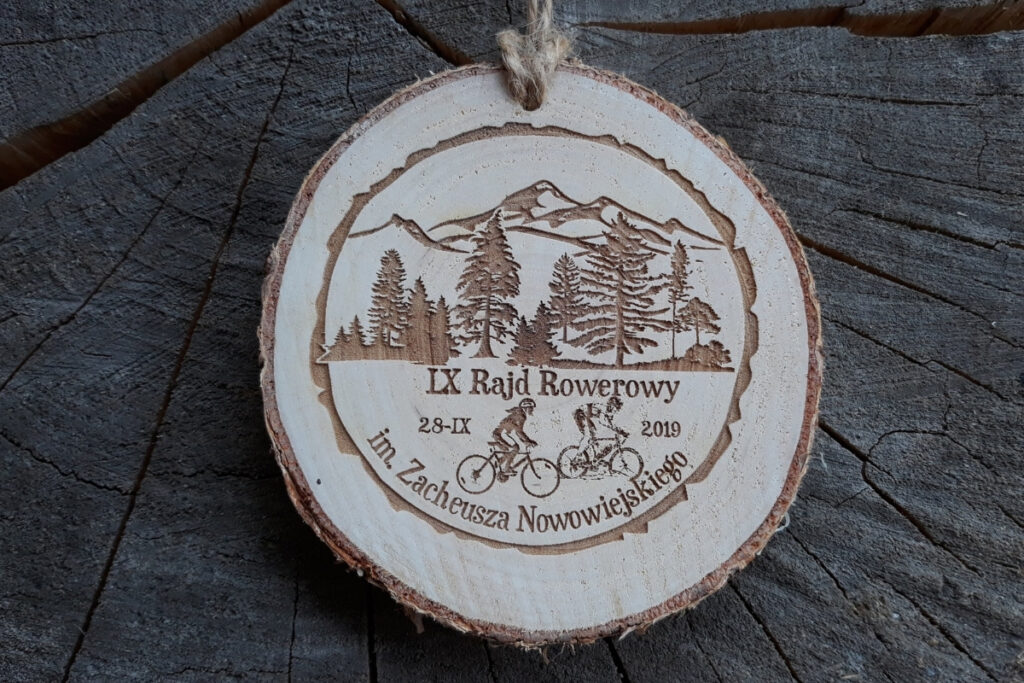 Medal wykonany z naturalnego plastra brzozy z korą, z grawerem roweru górskiego na tle gór i napisem Rajd Rowerowy.