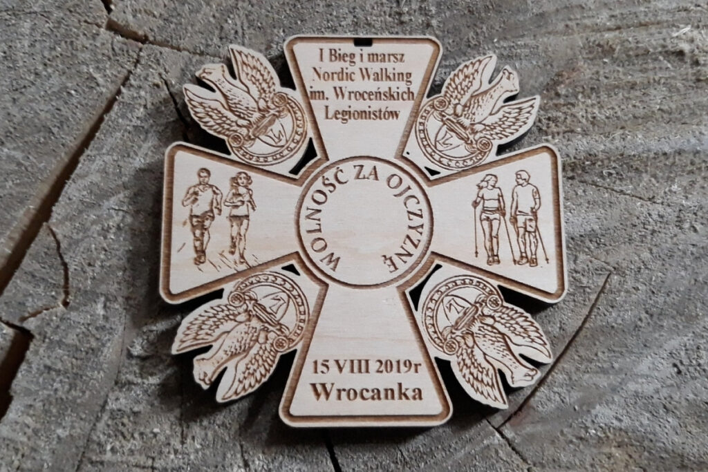 Medal patriotyczny z drewna z napisem Wolnoć za ojczyznę i 4 orłami.