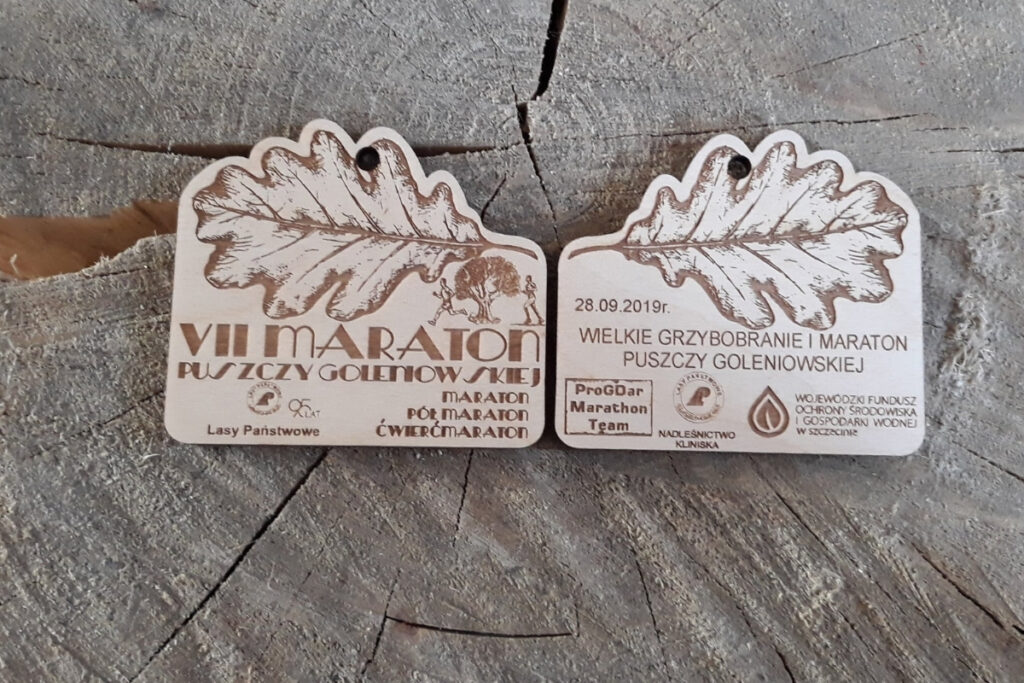 Medal Puszcza Goleniowska, drewniane trofeum biegowe, eko medal leśny, pamiątka z maratonu w lesie, grawerowany medal brzozowy, nagrody dla biegaczy trailowych.